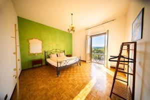 a bedroom with a bed with a green wall at Casa Burnie in Monte Molino