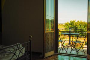 a room with a door open to a balcony with a table at Casa Burnie in Monte Molino +36 photos