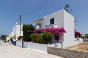 a white house with flowers on the side of it at Cycladic Grandma's Apartments in Parikia