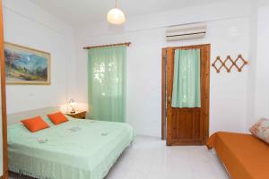 a white bedroom with a bed and a window at Cycladic Grandma's Apartments in Parikia