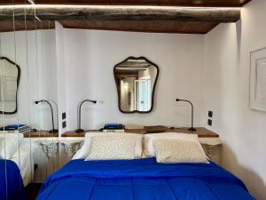 ein Schlafzimmer mit einem blauen Bett und einem Spiegel in der Unterkunft Casa Vacanza Eos in Sperlonga + 23 Fotos