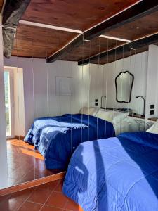 zwei Betten in einem Schlafzimmer mit blauen Laken in der Unterkunft Casa Vacanza Eos in Sperlonga