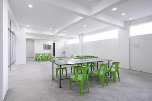 a room with a table and green chairs at FabHotel Vishwas in Aurangabad