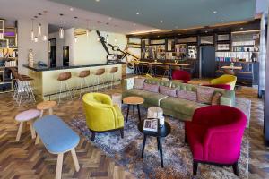 a lobby with a couch and chairs and a bar at ACHAT Hotel Braunschweig in Braunschweig