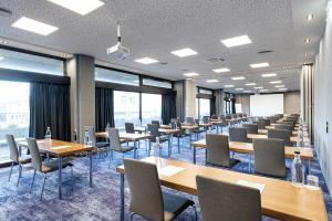 a conference room with tables and chairs and windows at ACHAT Hotel Braunschweig in Braunschweig