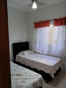 a bedroom with two beds and a window at Paz e tranquilidade in Indaiatuba