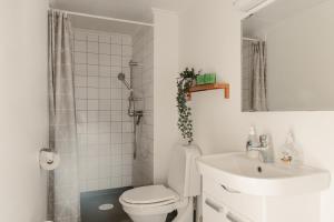 a white bathroom with a toilet and a sink at Äleklinta in Äleklinta