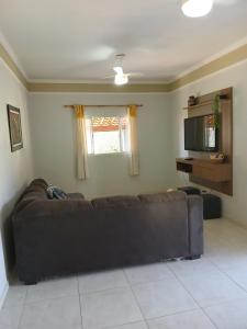 a living room with a couch and a television at Paz e tranquilidade in Indaiatuba