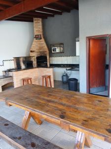 a large wooden table in a kitchen with a fireplace at Paz e tranquilidade in Indaiatuba