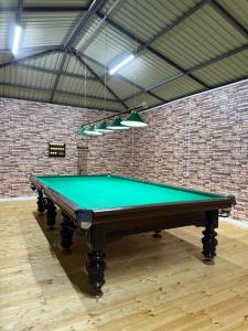 a pool table in a room with a brick wall at Гостевой дом Асель in Cholpon-Ata +48 photos