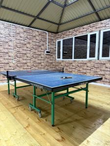 a ping pong table in a room with a brick wall at Гостевой дом Асель in Cholpon-Ata