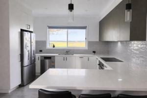 a kitchen with a white counter and a window at Agnes homestead in Welshpool