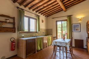 a kitchen with a table and a table and a window at Agriturismo Bike Hotel Podere Giarlinga in Massa Marittima