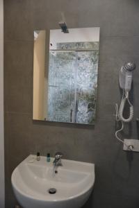 a bathroom with a white sink and a mirror at Farina Apartments in San Nicola La Strada +14 photos