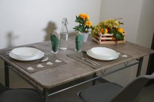 a table with two white plates on top of it at Farina Apartments in San Nicola La Strada