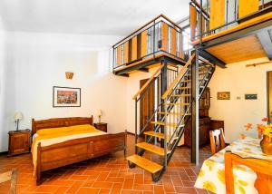 a bedroom with a bed and a wooden staircase at Agriturismo Bike Hotel Podere Giarlinga in Massa Marittima