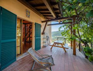 a porch with two benches and a table on it at Agriturismo Bike Hotel Podere Giarlinga in Massa Marittima