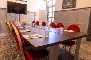 a conference room with a long table and chairs at Cromwell Lodge Hotel by Greene King Inns in Banbury