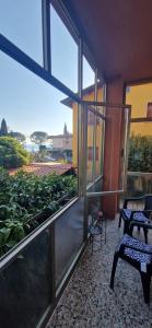 a room with a balcony with a view of plants at Casa rosario e annamaria in Torri del Benaco