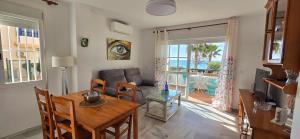 a living room with a table and a couch at Peñoncillo Beach in Torrox Costa