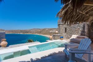 a villa with a swimming pool and a blue chair at Greco Philia Hotel Boutique by Mr and Mrs White in Elia Beach