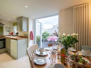 a kitchen and dining room with a wooden table with flowers at 3 Bed in Bridport oc-dc080 in Charmouth +18 photos