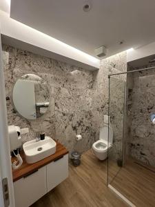 a bathroom with a sink and a toilet at Ferdinand Residence in Himare