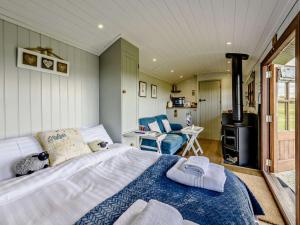 a bedroom with a bed and a wood stove at 1 Bed in Beaworthy oc-77361 in Ashwater