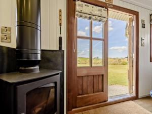 a kitchen with a stove and a door with a window at 1 Bed in Beaworthy oc-77361 in Ashwater
