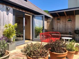 a red chair sitting on a patio with plants at 1 Bed in Okehampton oc-78087 in Hatherleigh