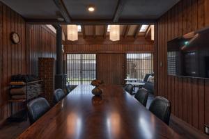 a large wooden table in a room with chairs at IZA moriyama in Moriyama