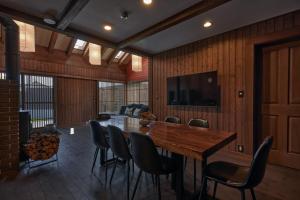 a dining room with a wooden table and chairs at IZA moriyama in Moriyama