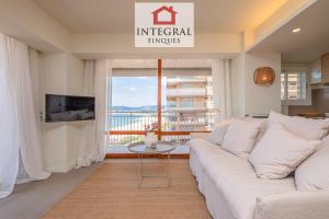a living room with a white couch and a large window at Horitzó Marí Palamós in Palamós
