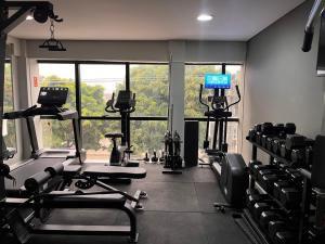 a room with a gym with chairs and a large window at Assay Plaza Hotel in Hortolândia