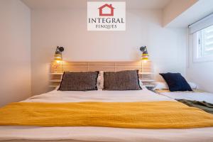 a bedroom with a large bed with a yellow blanket on it at Horitzó Marí Palamós in Palamós
