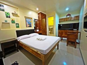 a bedroom with a bed and a desk and a piano at Marjhun's Apartelle in Jagna