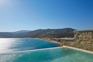 a swimming pool next to a beach next to the water at Greco Philia Hotel Boutique by Mr and Mrs White in Elia Beach