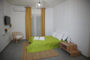 a bedroom with a green bed and a table at Farina Apartments in San Nicola La Strada