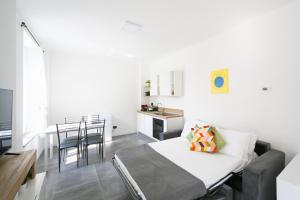 a bedroom with a bed and a kitchen with a table at KHL APARTMENTS - SanSiro, Milano in Milan