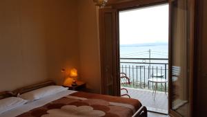 a bedroom with a bed and a large sliding glass door at Hotel Garden in Torri del Benaco