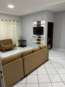 a living room with a couch and a flat screen tv at Casa nova 2 quartos in Montes Claros