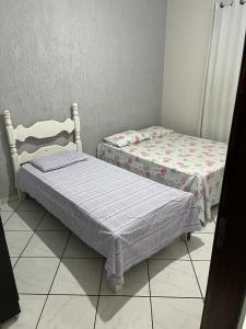 two twin beds in a room with at Casa nova 2 quartos in Montes Claros