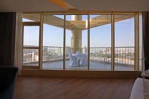 a room with a large window with a table on a balcony at Best Western Premier Riyadh in Riyadh