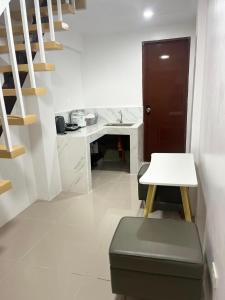 a room with a table and a stool and a table and stairs at K and E transient loft house in Puerto Princesa City