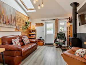 a living room with a leather couch and a chair at 2 Bed in Barnstaple oc-94038 in Bishops Tawton