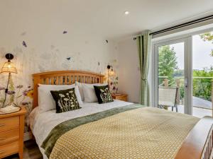 a bedroom with a large bed and a balcony at 2 Bed in Barnstaple oc-94038 in Bishops Tawton
