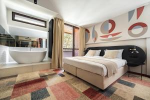 ein Schlafzimmer mit einem großen Bett und einer Badewanne in der Unterkunft Forest Hotel in Krakau