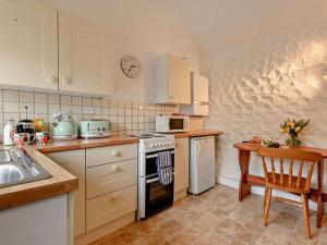 a kitchen with white cabinets and a stove top oven at 2 Bed in Minehead oc-90924 in Minehead