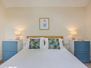a bedroom with a large bed with blue cabinets at 2 Bed in Taunton oc-96234 in West Quantoxhead +18 photos