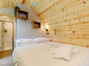 a bed in a room with a wooden wall at 2 Bed in Okehampton oc-92385 in Okehampton